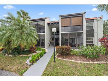 Exterior view of the condo building with landscaping at 3213 Beneva Rd # 201, Sarasota, FL 34232