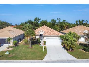 Aerial view of a single-Gathering home with a well-maintained lawn and a two-car garage at 8472 Gateway Ct, Englewood, FL 34224