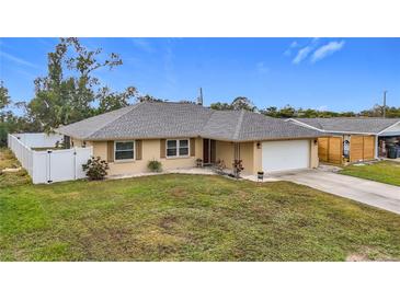Tan one-story house with gray roof, white fence, and driveway at 161 Sandhurst Dr, Venice, FL 34293