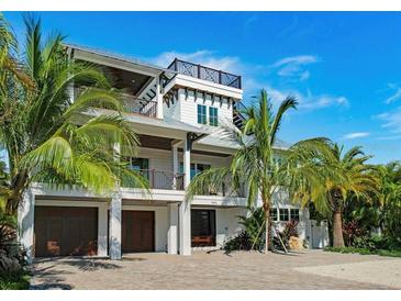 Stunning two-story home with a spacious driveway and lush landscaping at 9403 Gulf Dr, Anna Maria, FL 34216