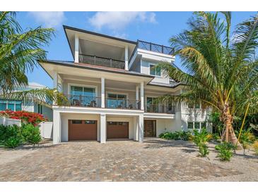 Two-story home with a modern design, two-car garage, and lush landscaping at 9407 Gulf Dr, Anna Maria, FL 34216