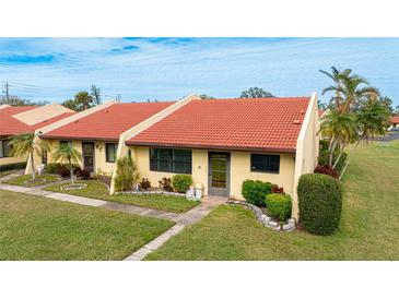 Spanish style condo, red tile roof, landscaped lawn at 1302 58Th W St, Bradenton, FL 34209