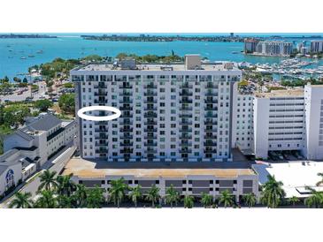 Aerial view of a modern condo building with water access and city views at 101 S Gulfstream Ave # 11E, Sarasota, FL 34236