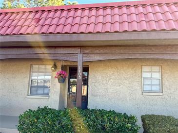 Exterior view of condo with red tile roof and landscaping at 601 N Hercules Ave # 1403, Clearwater, FL 33765