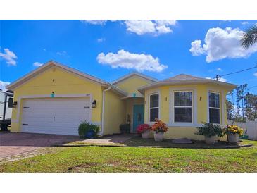 Charming yellow single-story home with a well-manicured lawn and attached two car garage at 1877 Dragonfly Ave, North Port, FL 34288