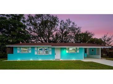 Charming Ranch home with a bright blue exterior, lush lawn, and attractive landscaping at 300 Coral Rd, Venice, FL 34293