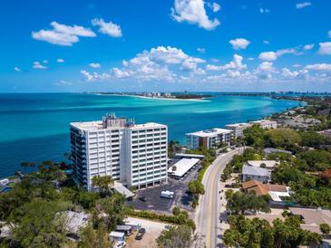 Aerial view of waterfront condo building with ocean and city views at 4822 Ocean Blvd # 8B, Sarasota, FL 34242