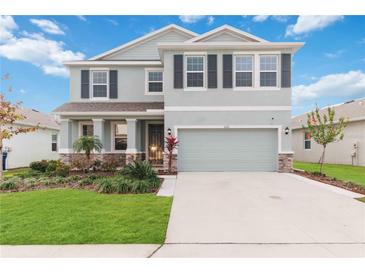 Charming two-story home boasts manicured lawn and a two-car garage, adding to its curb appeal at 5225 Grove Mill Loop, Bradenton, FL 34211