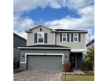 Two-story house with gray siding, dark gray shutters, and a two-car garage at 11608 Little River Way, Parrish, FL 34219