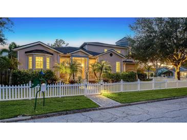 Evening view of charming two-story house with white picket fence and landscaping at 1714 Irving St, Sarasota, FL 34236