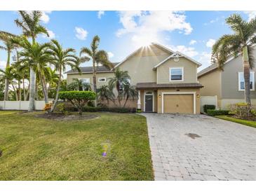 Two-story house with light beige siding, palm trees, and a paved driveway at 7000 Marina Dr, Holmes Beach, FL 34217