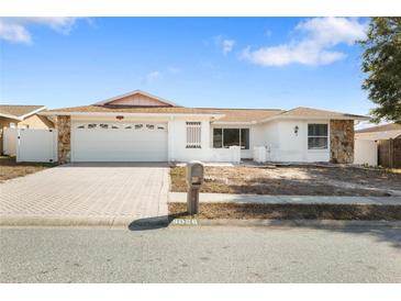 Ranch-style home with a two-car garage and brick driveway at 8026 Barberry Dr, Port Richey, FL 34668