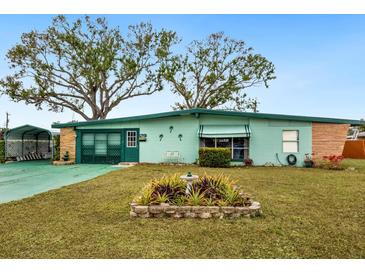 Ranch-style home with green exterior, mature trees, and landscaped yard at 1000 Dartmouth Dr, Bradenton, FL 34207
