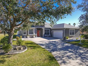 Gray house with red door, landscaping, and driveway at 2928 122Nd E Pl, Parrish, FL 34219