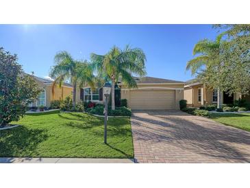 Single-Gathering home with a two-car garage and lush landscaping at 322 Siena Vista Pl, Sun City Center, FL 33573