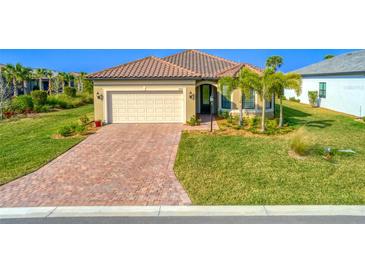 Single-story home with tile roof, paver driveway, and landscaped yard at 7675 Summerland Cv, Bradenton, FL 34202