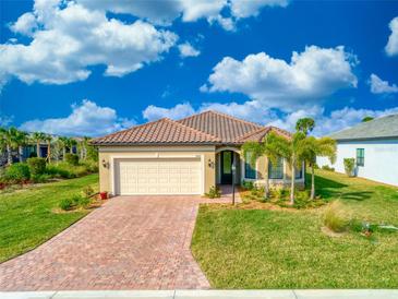 Single-story home with brick paver driveway and a two-car garage at 7675 Summerland Cv, Bradenton, FL 34202