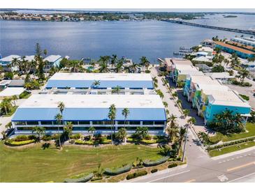 Aerial view of waterfront property, featuring colorful buildings and lush landscaping at 1007 Gulf N Dr # 106, Bradenton Beach, FL 34217