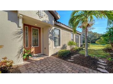 Inviting front entry with a decorative door and brick walkway at 5846 Cavano Dr, Sarasota, FL 34231
