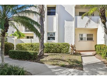 Neat condo building exterior with manicured landscaping and walkway at 760 Village Cir # 109, Venice, FL 34292