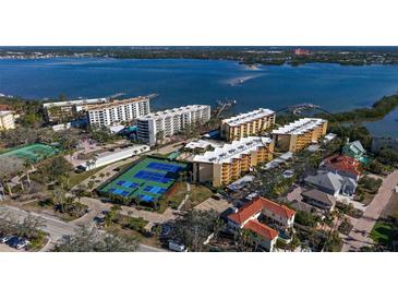 Aerial view of waterfront condo community with tennis courts and marina at 8779 Midnight Pass Rd # 504H, Sarasota, FL 34242