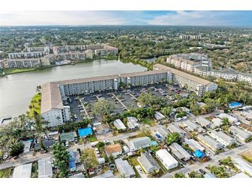 Aerial view of a large condominium complex situated on a lake, surrounded by other buildings and lush greenery at 3256 Lake Bayshore Dr # O-507, Bradenton, FL 34205