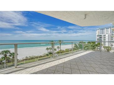 Enjoy breathtaking beach views from the spacious balcony, complete with tile flooring and modern glass railings at 1800 Benjamin Franklin Dr # A405, Sarasota, FL 34236