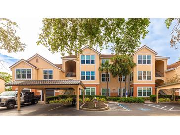 Front view of a two-story condo building with parking and landscaping at 4142 Central Sarasota Pkwy # 1428, Sarasota, FL 34238