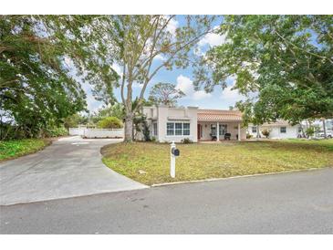 Single-story home with a terracotta roof, driveway, and mature landscaping at 7705 Alhambra Dr, Bradenton, FL 34209