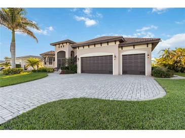 Beautiful Mediterranean home with lush landscaping and a paved driveway leading to a two-car garage at 1111 Socorro Dr, Punta Gorda, FL 33950