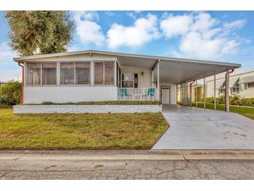 Single-wide manufactured home with carport and covered porch at 1523 46Th E Ave, Ellenton, FL 34222