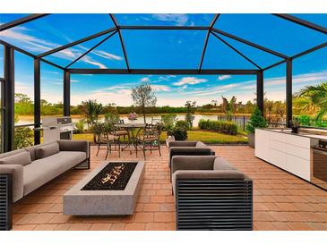 Relaxing outdoor space with covered patio, fire pit, and lake view at 20861 Cattail Blvd, Venice, FL 34292