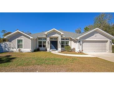 Single-story home with gray exterior, two-car garage, and landscaped lawn at 2155 Jagust Rd, North Port, FL 34288