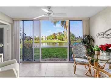 Bright sunroom with sliding glass doors offering scenic pond views at 4440 Fairways Blvd # 103, Bradenton, FL 34209