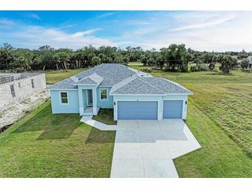 New construction home with a three-car garage and spacious lawn at 75 Mark Twain Ln, Rotonda West, FL 33947