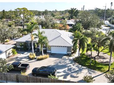 Single-Gathering home with a large driveway, two cars, and lush landscaping at 3011 Ashton Rd, Sarasota, FL 34231