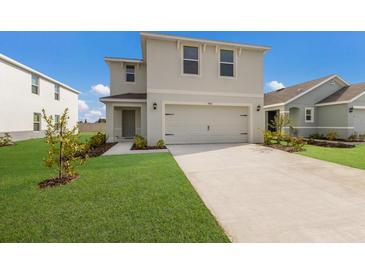 Two-story house with a two-car garage and landscaped lawn at 5846 Silver Moonlight Dr, Palmetto, FL 34221