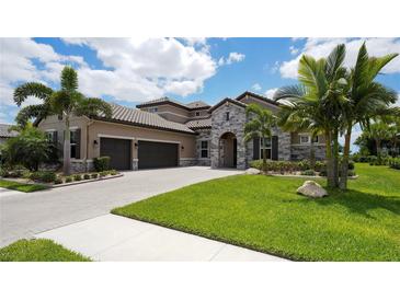Luxury home with stone accents, three-car garage, and lush landscaping at 6337 Rivo Lakes Blvd, Sarasota, FL 34241