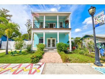 Charming two-story light teal home with a balcony and landscaped yard at 1110 12Th W St, Bradenton, FL 34205