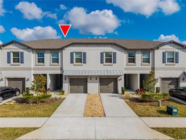 Modern townhome exterior with two-car garage and landscaping at 14350 Easy Goer St, Ruskin, FL 33573