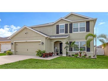 Two-story house with a green facade, landscaping, and a two-car garage at 15812 High Bell Pl, Bradenton, FL 34212