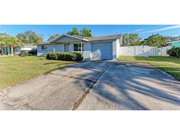 Ranch style home with a large yard, driveway, and attached garage at 2915 Bucida Dr, Sarasota, FL 34232