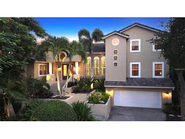 Stunning two-story home with a three-car garage and lush landscaping at 3310 Sabal Cove Ln, Longboat Key, FL 34228