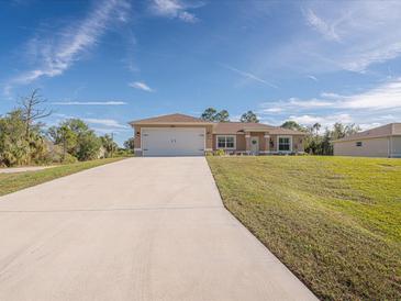 Single-story home with a two-car garage and a long driveway at 4050 Dragon Street St, North Port, FL 34288