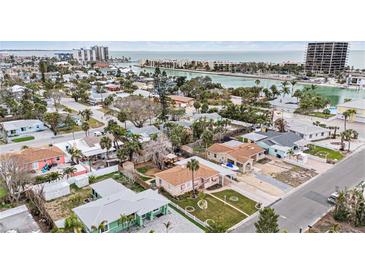 Aerial view of a charming coastal neighborhood with a focus on a single-Gathering home and lush landscaping at 550 80Th Ave, St Pete Beach, FL 33706