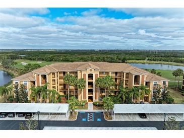 Aerial view of condo building with parking and golf course views at 8105 Grand Estuary Trl # 307, Bradenton, FL 34212