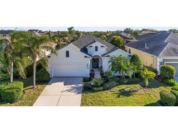 White house with gray roof, two-car garage, and lush landscaping at 11422 Griffith Park Ter, Bradenton, FL 34211