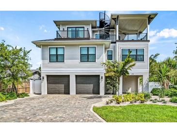 Three-story house with two-car garage, spiral staircase, and landscaped yard at 171 Mckinley Dr, Sarasota, FL 34236