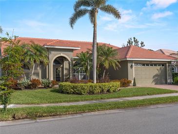 Single-story home with tile roof, palm trees, and landscaped yard at 4472 Via Del Villetti Dr, Venice, FL 34293