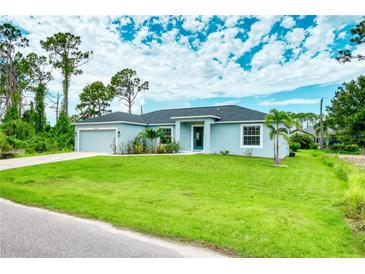 Single-story home with a spacious lawn and attached garage at 5371 Fleming St, Port Charlotte, FL 33981